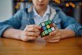 Boy trying to solve puzzle cube, focus on hands