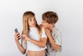 Boy trying to spy a girl`s mobile phone but the girl noticed it Royalty Free Stock Photo