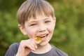 Boy trying to taste the Bitcoin in the summer in the Park. Royalty Free Stock Photo