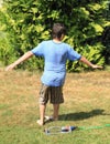 Boy twisting behind sprinkler