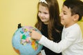 Boy with two girls look at the globe and search different continets and coutries