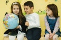 Boy with two girls look at the globe and search different continets and coutries Royalty Free Stock Photo