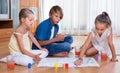 Boy and two girls playing at board game indoors Royalty Free Stock Photo