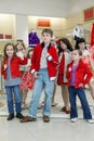 Boy with two girls trying on clothes together with mannequins