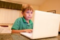 Boy typing on white laptop