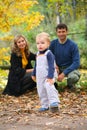 Boy with untied lace and parents in park Royalty Free Stock Photo