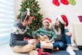 Boy Unwrapping Gifts With Parents At Home