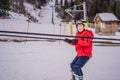 Boy uses a training lift. Child skiing in mountains. Active toddler kid with safety helmet, goggles and poles. Ski race Royalty Free Stock Photo