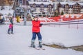 Boy uses a training lift. Child skiing in mountains. Active toddler kid with safety helmet, goggles and poles. Ski race Royalty Free Stock Photo