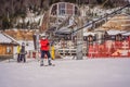 Boy uses a training lift. Child skiing in mountains. Active toddler kid with safety helmet, goggles and poles. Ski race Royalty Free Stock Photo