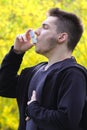 Boy using asthma inhaler in park, lung disease Royalty Free Stock Photo