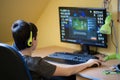 Boy using computer at home, playing game