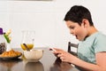 Boy using digital tablet during breakfast in kitchen Royalty Free Stock Photo