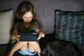 Boy using digital tablet computer playing games or watching cartoons at home. Royalty Free Stock Photo