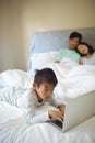 Boy using laptop in bedroom Royalty Free Stock Photo