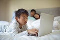 Boy using laptop in bedroom Royalty Free Stock Photo