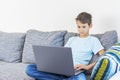 Child using laptop computer at home. Technology, online learning, distance education, home studying, homework