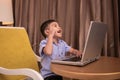 A boy using a laptop and getting ideas