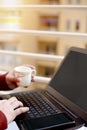 Boy is using laptop with holding cup in hand Royalty Free Stock Photo