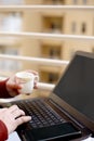 Boy is using laptop with holding tea cup in hand Royalty Free Stock Photo