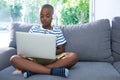 Boy using laptop while listening to headphones at home Royalty Free Stock Photo