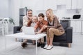 boy using laptop near smiling grandparents