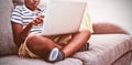 Boy using laptop while sitting with crossed legged on sofa at home