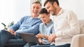 Boy Using Laptop Sitting Between Father And Grandpa At Home Royalty Free Stock Photo