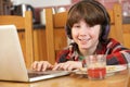 Boy Using Laptop Whilst Eating Breakfast Royalty Free Stock Photo