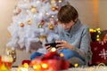 Boy using mobile phone at home in Christmas time Royalty Free Stock Photo