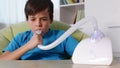 Boy using nebulizer inhaler with mouthpiece