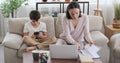 Boy using phone and interrupting mother working from home