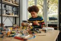 Do the right thing. Boy using screwdriver while fixing bolts on a robot vehicle. Smart kids and STEM education. Royalty Free Stock Photo