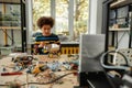 Quality in Every Work. Boy using screwdriver while fixing bolts on a robot vehicle. Smart kids and STEM education. Royalty Free Stock Photo