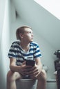 Boy using smartphone in bathroom Royalty Free Stock Photo