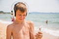 Boy using a smartphone on the beach summer day Royalty Free Stock Photo