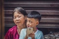 Boy using smartphone while sitting on his mother lap