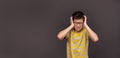 The boy is very emotional and tense, screaming in pain, holding his head. Boy annoyed by loud noise having panic attack Royalty Free Stock Photo