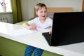 Boy video conferencing with tutor on laptop at home. Distance education concept Royalty Free Stock Photo