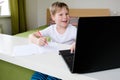 Boy video conferencing with tutor on laptop at home. Distance education concept Royalty Free Stock Photo