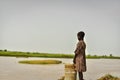 A boy from a village standing close to a river