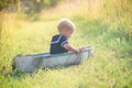 Boy in vintage sailor suit in boat on grass