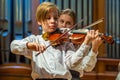 A boy violonist on the stage.