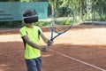 Boy in virtua; reality glasses with racket in his hands is practicing playing tennis with virtual trainer. Royalty Free Stock Photo