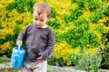 Boy walking with a blue watering can