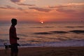 A boy walking with a dog during the sunset in a ocean Royalty Free Stock Photo