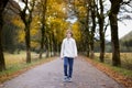 Boy walking down road between yellow trees