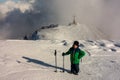 Boy with walking poles visiting a monument on the mountain Royalty Free Stock Photo