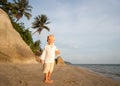 Boy walking on a tropical beach at sunset Royalty Free Stock Photo