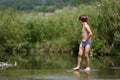 Boy walking in the water bare feet